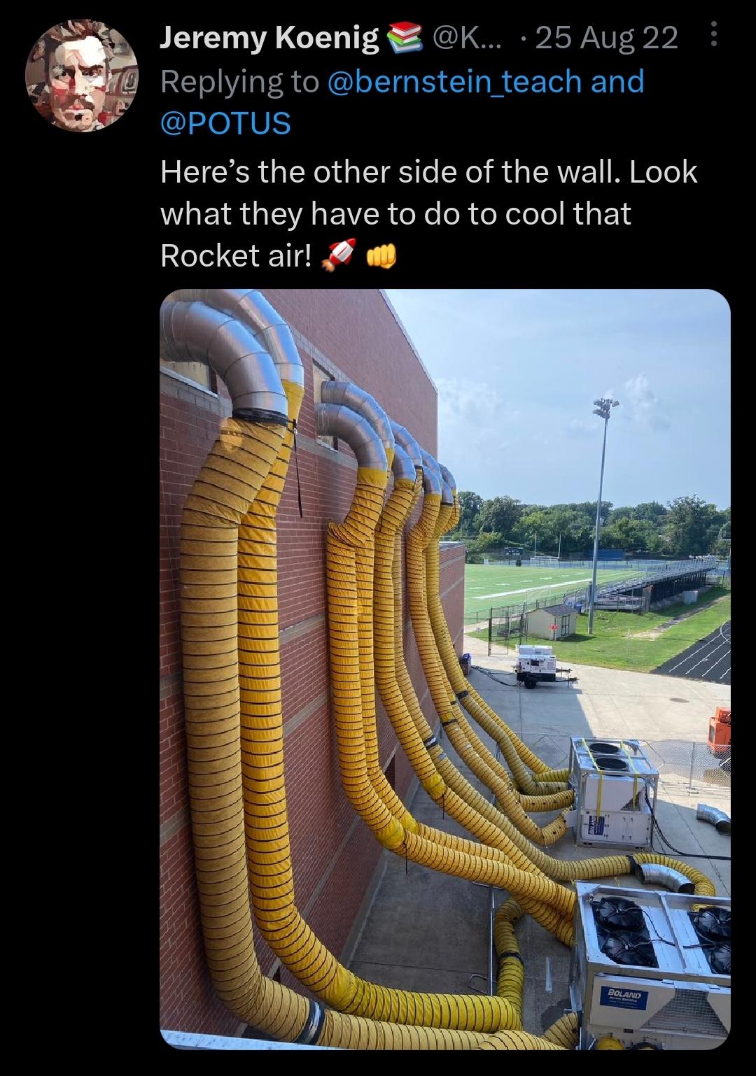 Screenshot of a tweet from Jeremy Koenig dated 25 Aug 22. Caption reads '@bernstein_teach and @POTUS Here's the other side of the wall. Look what they have to do to cool that Rocket air 🚀👊'. The photo shows the outside wall of a high school gymnasium whose windows have been removed and fitted with some large air ducts connected to a high-end AC/ventilation setup